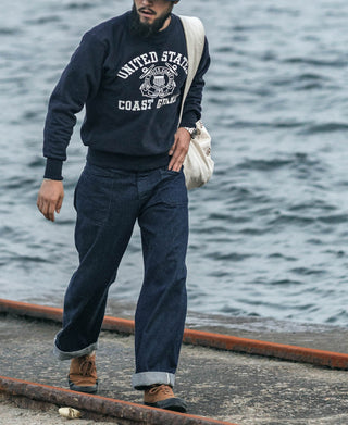 Dark navy denim pants on a model, relaxed fit with cuffed hem and front pockets