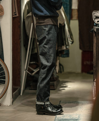 Indigo selvedge denim jeans on model, straight leg cuff with visible hem detailing