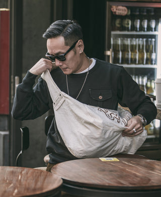 Black military pocket sweatshirt with flap chest pocket, worn by model.