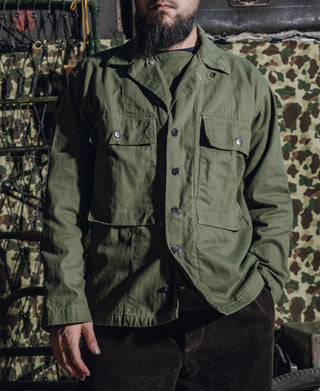 Olive green HBT jacket worn: button front, chest pockets, and metal buttons