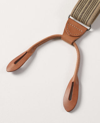 Brown leather end tabs with stitched details on khaki striped suspender straps