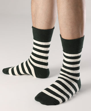 Green and white striped crew socks on feet with ribbed cuffs