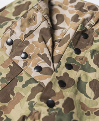 Reversible duck hunter camo pants fabric close-up with metal buttons and flap