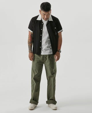 Olive Gurkha bermuda pants on model with straight legs and rolled cuffs