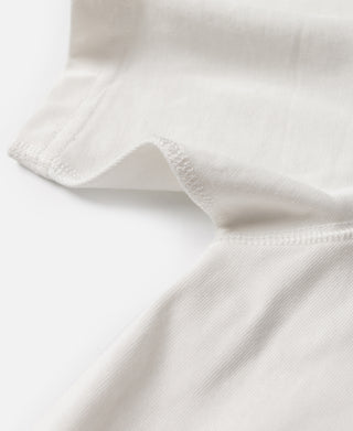 White cotton henley T-shirt fabric close-up at the sleeve hem and shoulder
