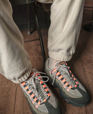 Light cream cuffed sweatpants with sneakers; lace-up shoes in view