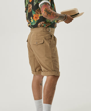 Khaki bermuda shorts on model with buttoned cargo pockets and belt