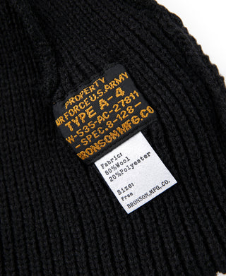 Black knit watch cap with rectangular woven label and care info