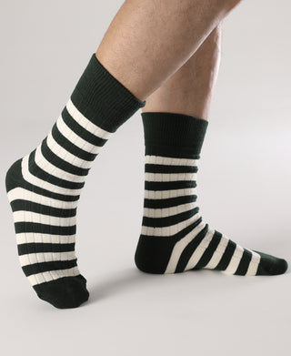 Green and white striped crew socks with ribbed cuffs on standing legs