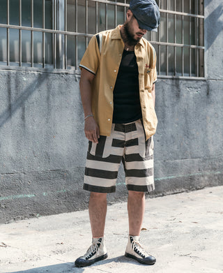 Black cotton tank top worn under a tan short-sleeve button shirt; ribbed fabric