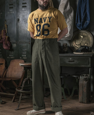 Olive utility fatigue pants on model, relaxed fit and button fly
