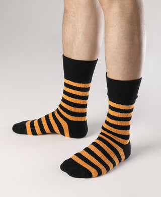 Black crew socks with orange-and-black striped pattern, full foot view.
