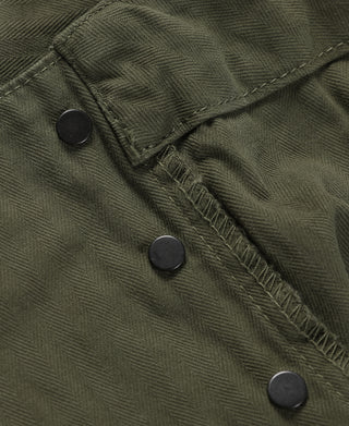 Close-up of olive cargo shorts with black buttons and flap details