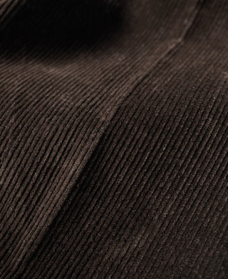 Close-up of dark brown corduroy texture with vertical ribbed pattern.