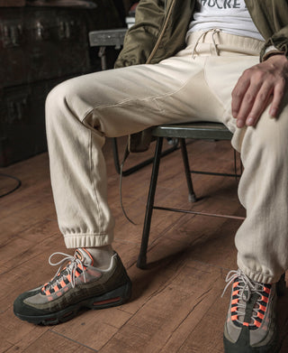 Light cream terry sweatpants with ribbed cuffs, worn while seated