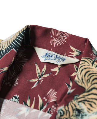 Wine red aloha shirt collar close-up with brand label and tiger-and-crane pattern