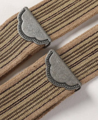 Close-up of khaki striped fabric with gray leather end caps and riveted edge