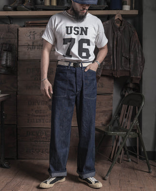 Indigo denim fatigue dungaree pants worn with black belt and lace-up shoes
