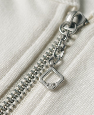 White quarter-zip t-shirt zipper pull with TALON hardware close-up