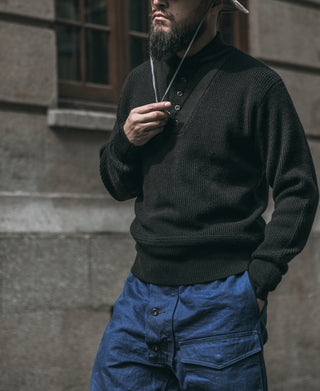 Black wool high-neck pullover sweater with button placket, ribbed cuffs, and side pouch