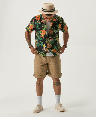 Khaki bermuda shorts on model with relaxed fit and pleated front