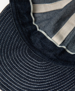 Indigo denim A-3 style cap detail with off-white fabric trim at front seam