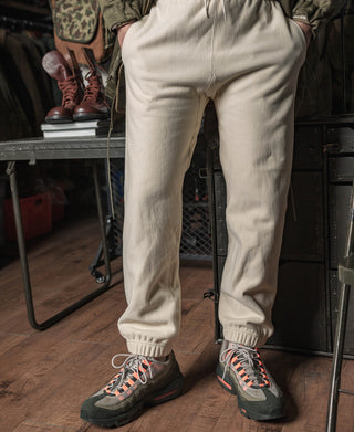Light cream jogger-style sweatpants with elastic cuffs and drawcord waistband