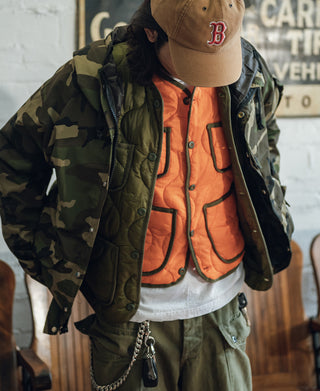 Orange quilted padded vest with dark patch pockets and button front under jacket