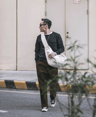 Black military pocket sweatshirt with front flap pocket, full-body model view.