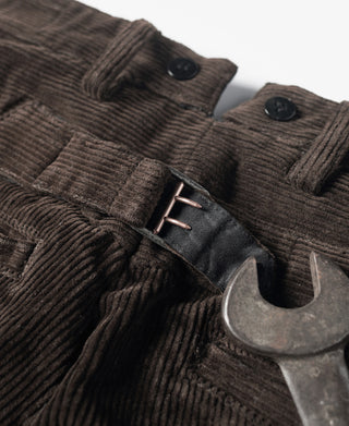 Corduroy pants belt loops and button closure with dark hardware detail.