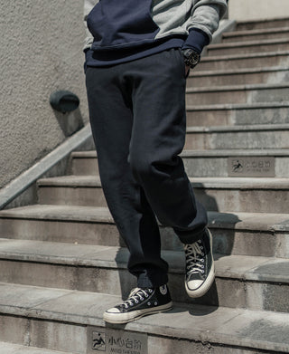 Black terry sweatpants with tapered leg and ribbed elastic ankle cuffs