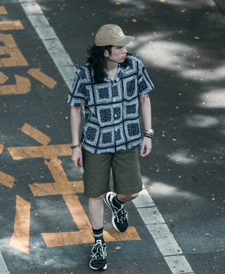 Khaki 5-panel cap with curved brim, model seen from behind and side