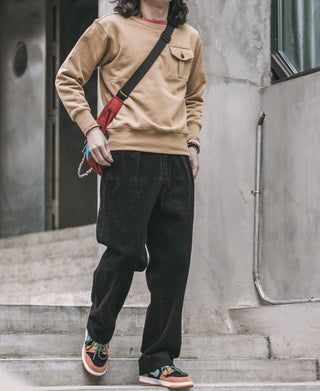 Khaki crewneck sweatshirt with chest pocket, shown on model from the side