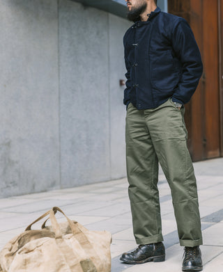 Olive M-43 field trousers on person, side view with cuffed hems and belt loops