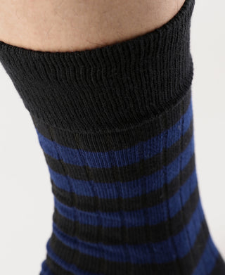 Close-up of black cotton sock with blue stripe bands