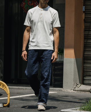 White cotton short-sleeve henley T-shirt worn by a man, button placket at neck