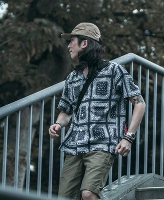 Khaki 5-panel cap with curved brim, side view from model