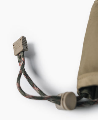 Adjustable cap drawcord with plastic clasp on olive nylon cap