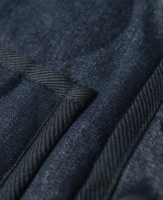 Navy quilted denim vest fabric close-up with textured diagonal paneling