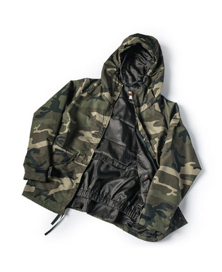 Woodland camo parka laid flat with hood and black-lined interior.