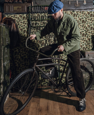 Olive green HBT jacket worn with collar, chest pockets, and buttoned sleeves