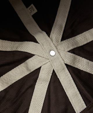 Dark brown cap lining with beige starburst panels and center snap button