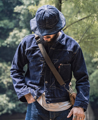 Indigo denim bucket hat with stitched brim and crown seams, worn with a denim jacket