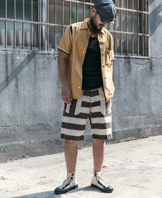 Striped denim newsboy cap worn by a man, dark blue with white pinstripes and curved brim.