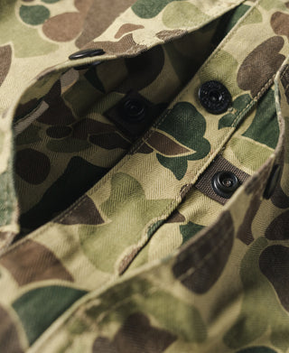 Camouflage jacket interior pocket opening with two snap buttons