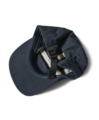 Navy 5-panel cap with chin strap folded inside and adjustable webbing detail