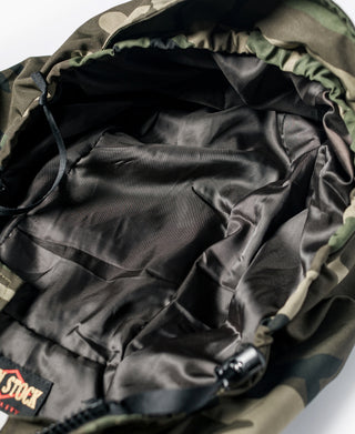 Woodland camo parka interior close-up with black lining and drawcord ties.