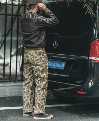 Reversible camo pants worn by a person, side view in green tan camouflage pattern
