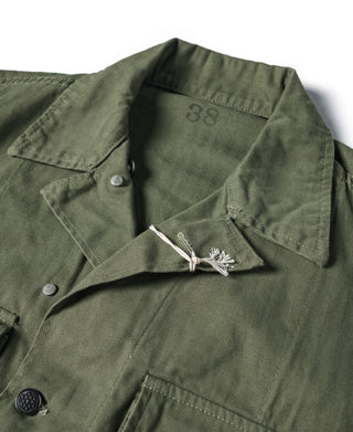 Olive green HBT jacket collar label marked '88' with eagle-style pin detail