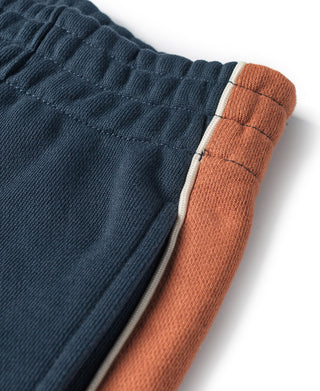 Navy waistband and cuff with rust side stripe and stitched trim
